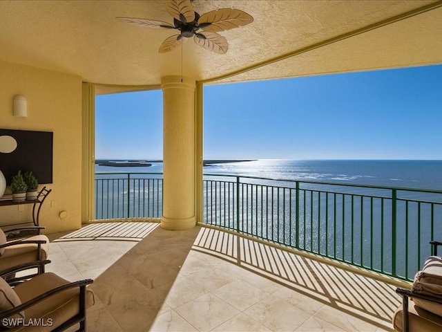 balcony with a water view and ceiling fan