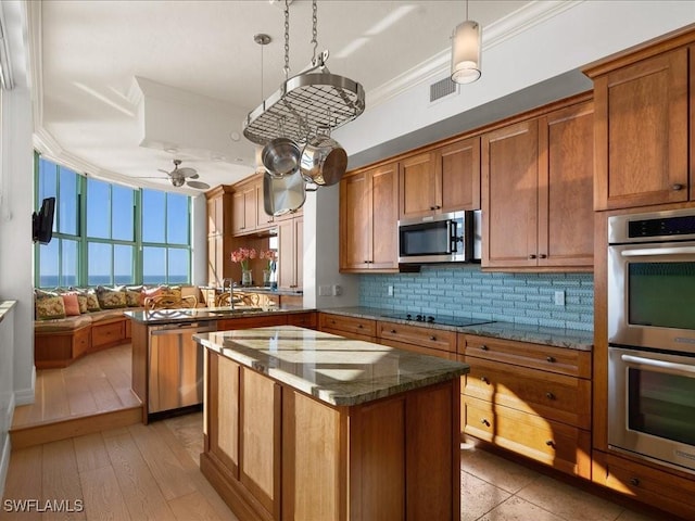 kitchen featuring a kitchen island, tasteful backsplash, hanging light fixtures, stainless steel appliances, and crown molding