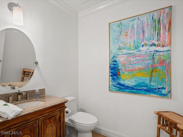 bathroom with ornamental molding, toilet, and vanity