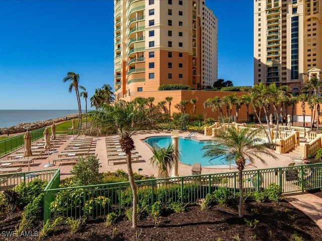 view of swimming pool with a patio area and a water view