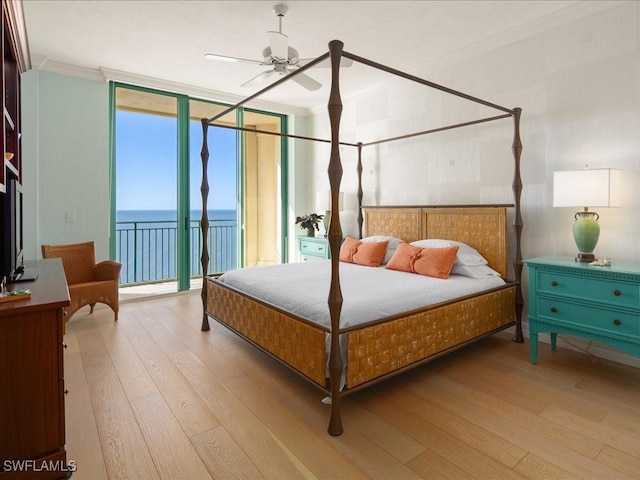 bedroom featuring a water view, crown molding, access to outside, expansive windows, and light hardwood / wood-style floors