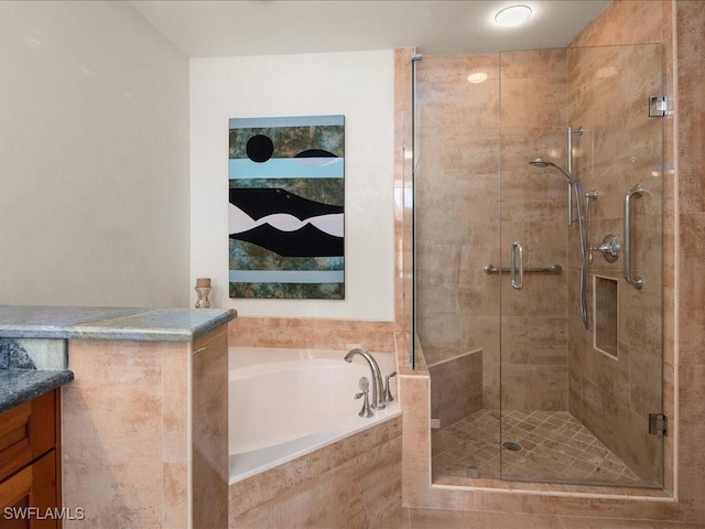 bathroom with vanity and shower with separate bathtub