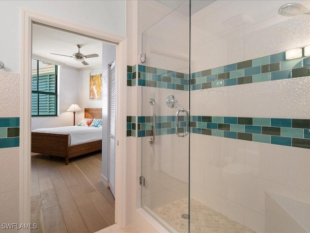 bathroom featuring wood-type flooring, an enclosed shower, and ceiling fan