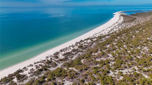 bird's eye view featuring a water view and a beach view