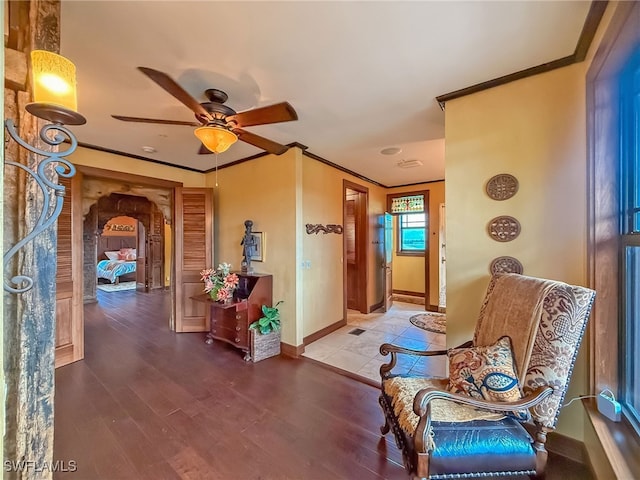 sitting room featuring hardwood / wood-style flooring, ornamental molding, and ceiling fan