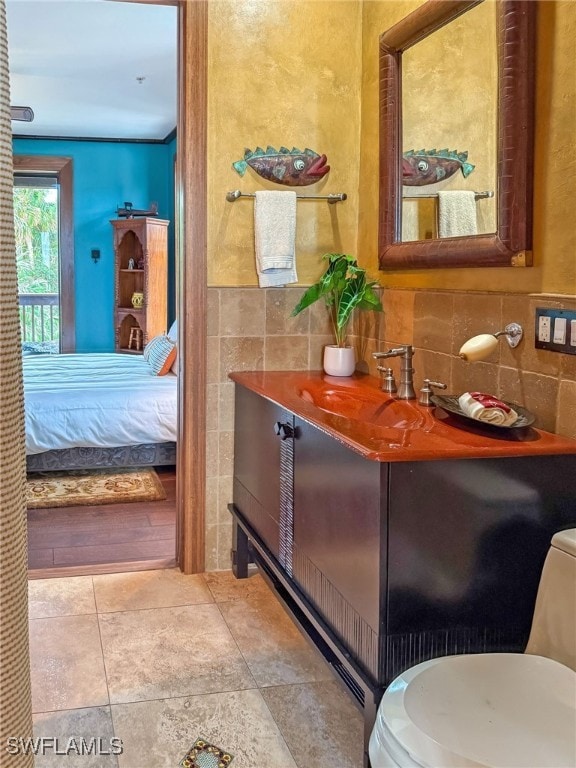 bathroom with vanity, tile walls, tile patterned floors, and toilet