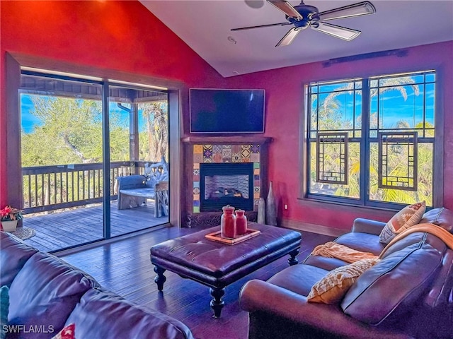 living room featuring hardwood / wood-style flooring, ceiling fan, a fireplace, and vaulted ceiling