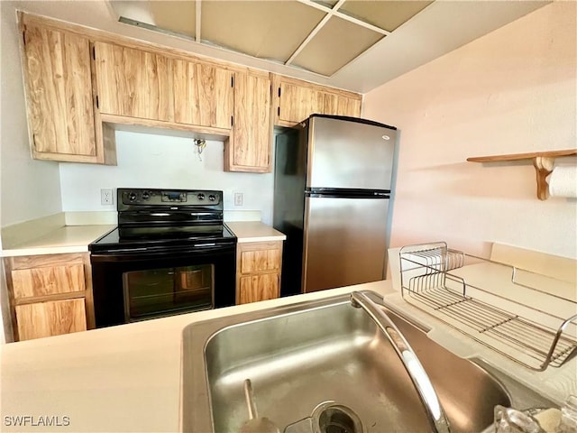 kitchen featuring light brown cabinets, stainless steel refrigerator, and black / electric stove