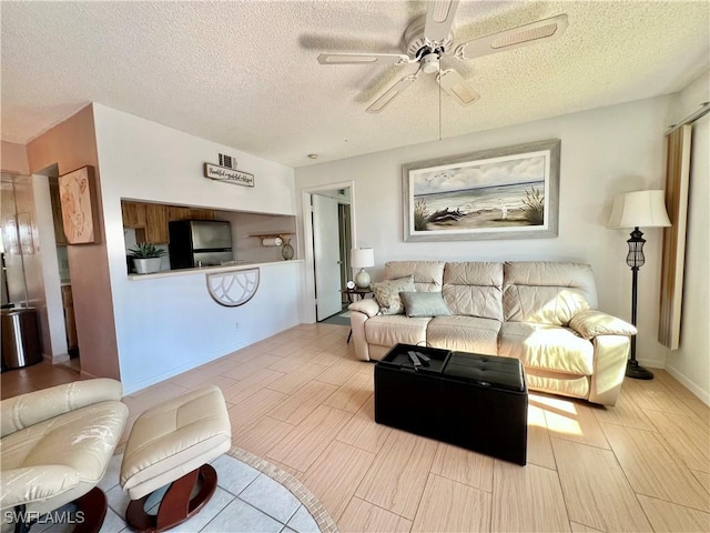 living room featuring a textured ceiling and ceiling fan