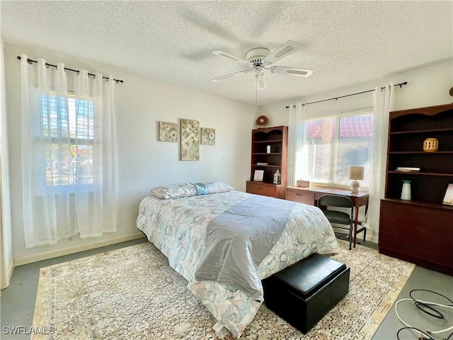 bedroom with ceiling fan, multiple windows, and a textured ceiling