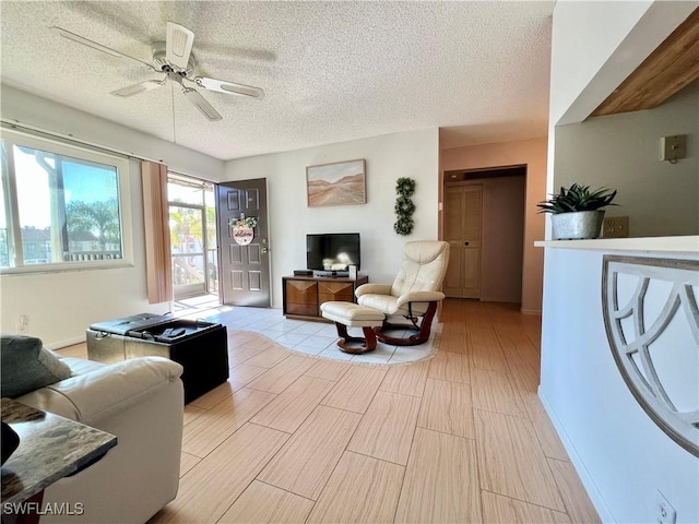 living room with ceiling fan and a textured ceiling