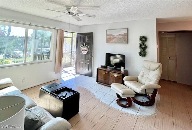 living room with ceiling fan and a textured ceiling