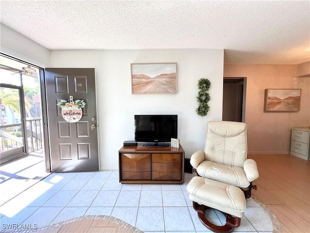 living room featuring a textured ceiling and light tile patterned floors