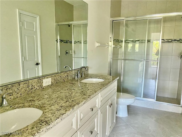 bathroom with vanity, toilet, a shower with shower door, and tile patterned flooring