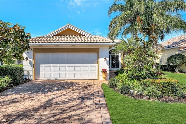 view of front of property with a garage and a front lawn