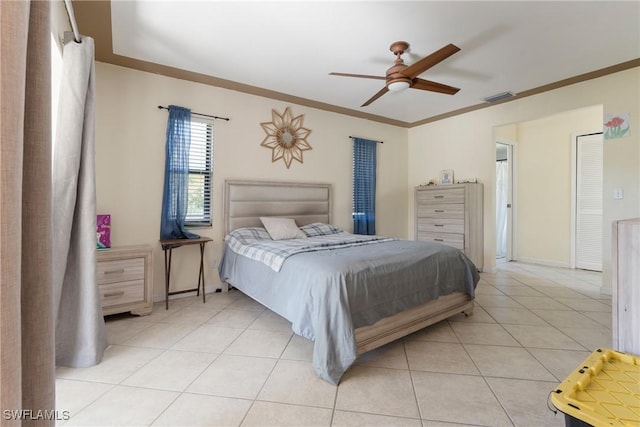 bedroom with ceiling fan, ornamental molding, and light tile patterned floors