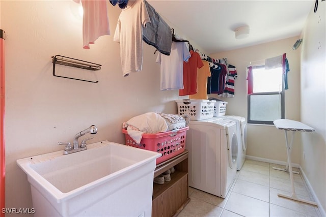 clothes washing area featuring separate washer and dryer, sink, and light tile patterned floors