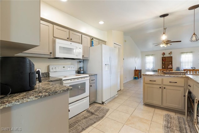 kitchen with lofted ceiling, dark stone countertops, hanging light fixtures, light tile patterned floors, and white appliances