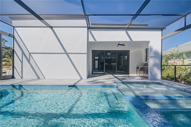 view of swimming pool with a patio area, ceiling fan, and glass enclosure