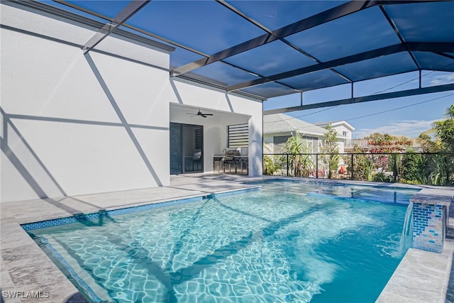 view of pool with pool water feature, ceiling fan, a patio, and glass enclosure