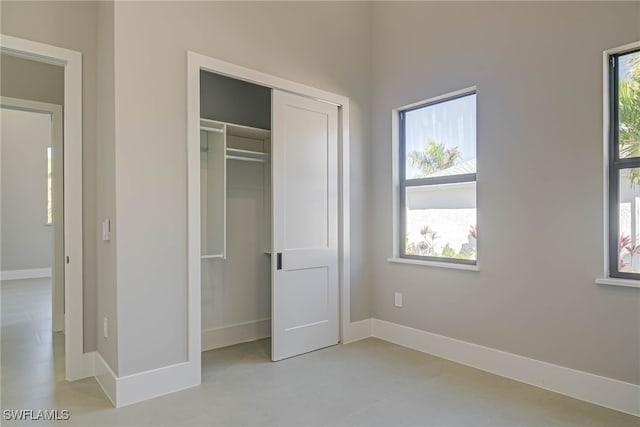 unfurnished bedroom with multiple windows and a closet