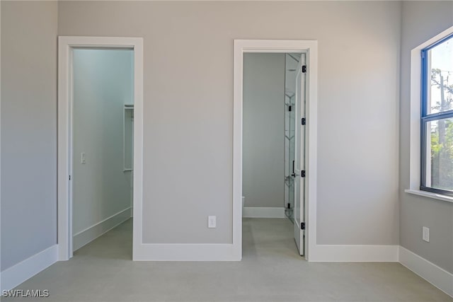 unfurnished bedroom featuring a walk in closet