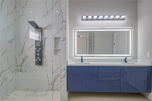 bathroom featuring tiled shower and vanity