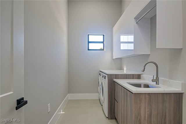 laundry room featuring sink, washer and clothes dryer, and cabinets