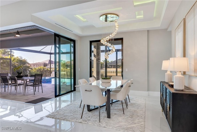 dining area featuring a tray ceiling and a notable chandelier