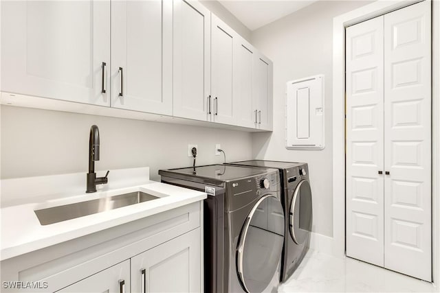 laundry area with separate washer and dryer, sink, electric panel, and cabinets