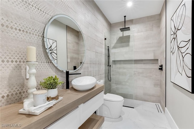 bathroom with tile walls, vanity, tasteful backsplash, a tile shower, and toilet