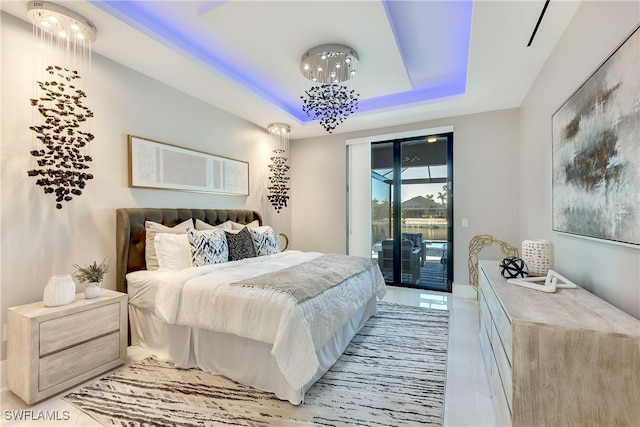 bedroom featuring access to exterior and a raised ceiling