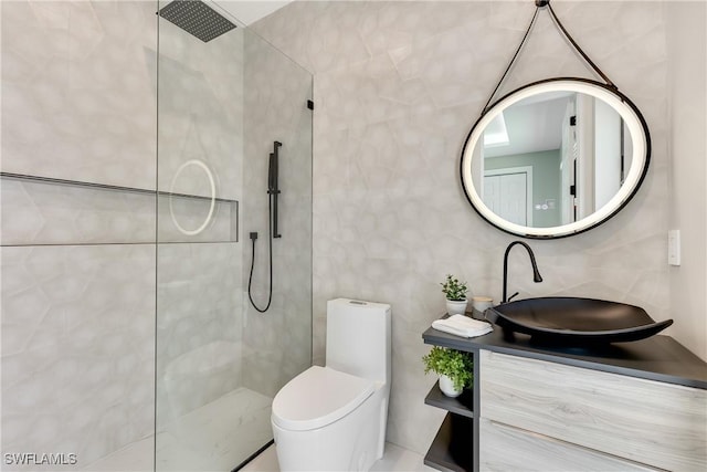 bathroom featuring vanity, toilet, tile walls, and a tile shower