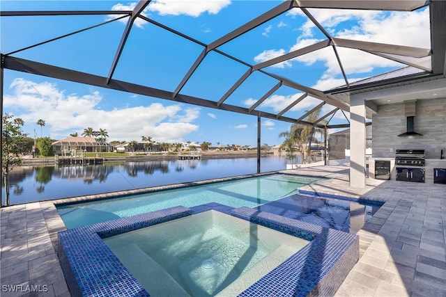 view of pool featuring exterior kitchen, an in ground hot tub, a water view, and glass enclosure