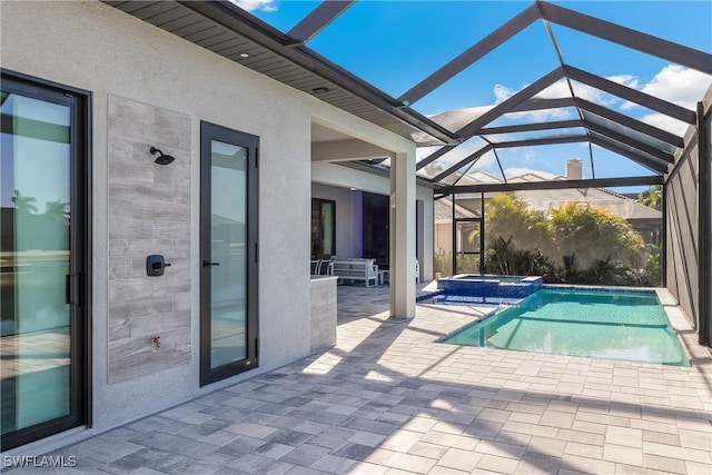 view of swimming pool with a patio, glass enclosure, and an in ground hot tub