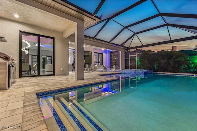 pool at dusk with a lanai, a patio, and an in ground hot tub