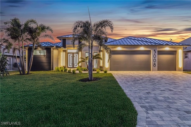 view of front of home featuring a garage and a lawn