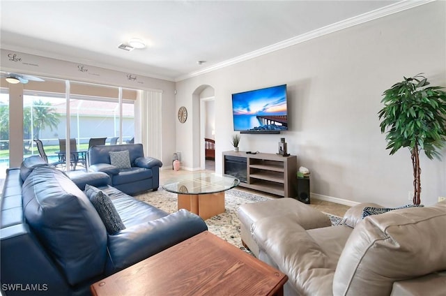 living room featuring ornamental molding, arched walkways, and baseboards