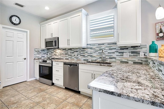 kitchen with visible vents, decorative backsplash, appliances with stainless steel finishes, white cabinetry, and a sink