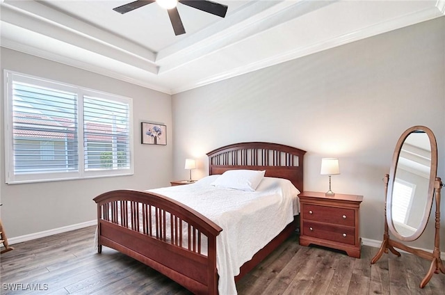 bedroom with dark hardwood / wood-style flooring, ornamental molding, a raised ceiling, and ceiling fan