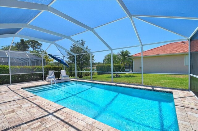 view of swimming pool with a yard, a lanai, and a patio area