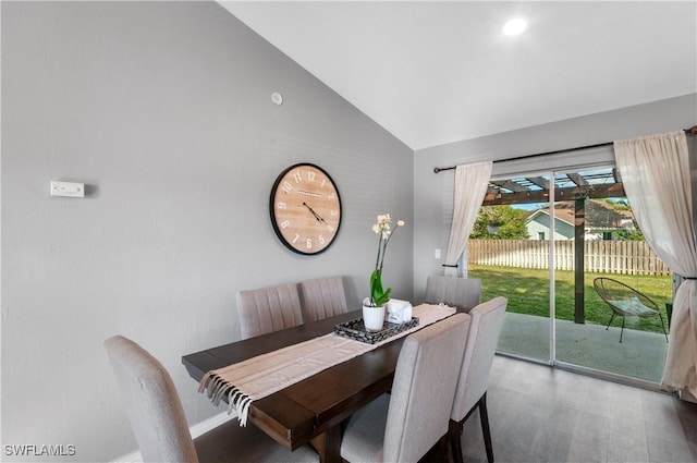 dining room featuring lofted ceiling and wood-type flooring