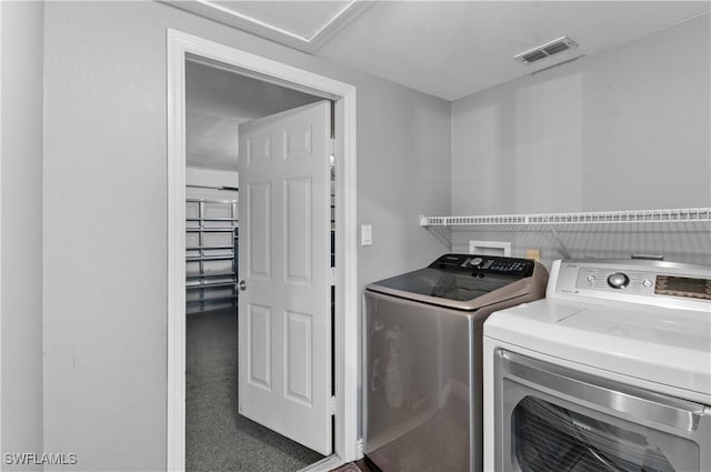 laundry room featuring dark colored carpet and separate washer and dryer