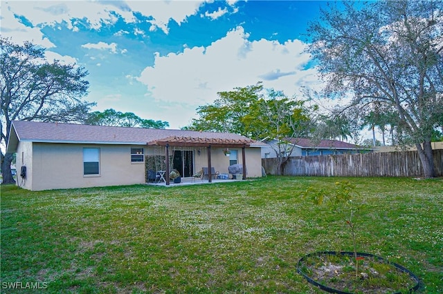 rear view of property featuring a patio and a yard