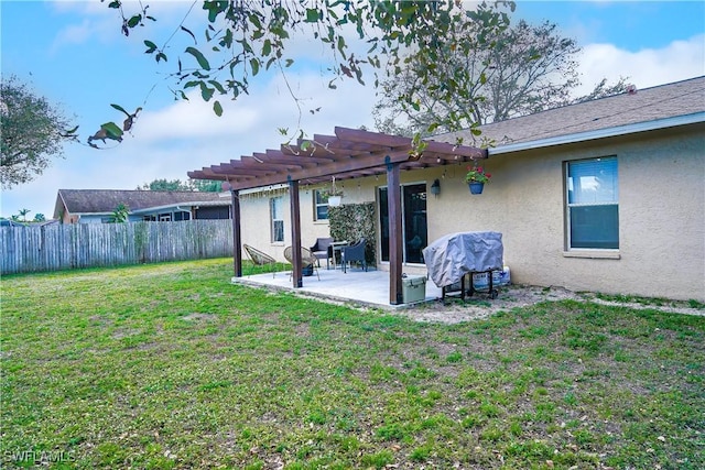 rear view of property with a yard, a pergola, and a patio