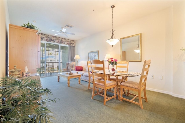 carpeted dining area with ceiling fan