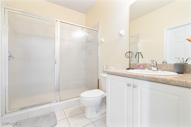 bathroom with tile patterned flooring, vanity, toilet, and walk in shower