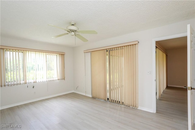 spare room with ceiling fan, light hardwood / wood-style flooring, and a textured ceiling