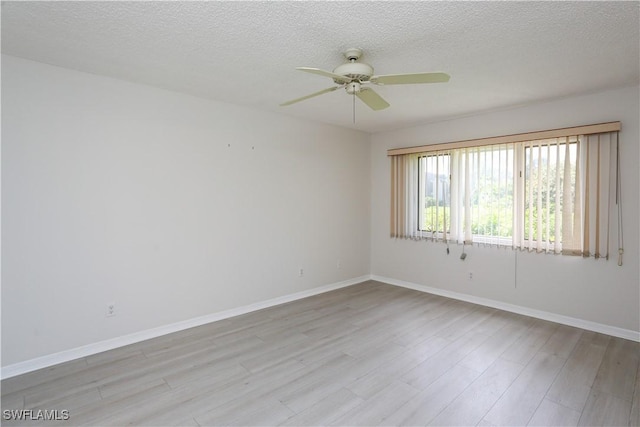 empty room with a textured ceiling, ceiling fan, and light hardwood / wood-style flooring