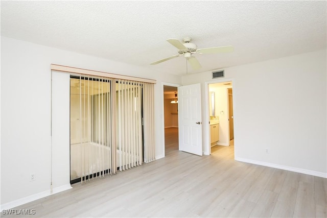 unfurnished room with ceiling fan, a textured ceiling, and light wood-type flooring